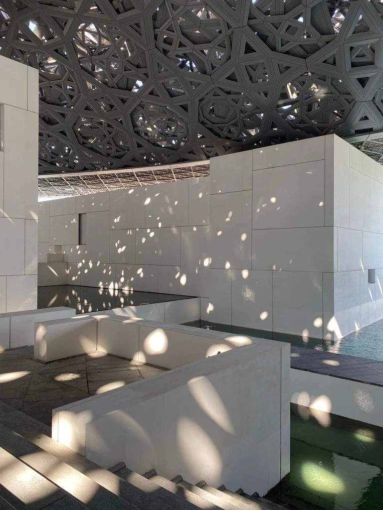 Louvre Abu Dhabi dome with light perforations at golden hour